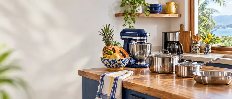 Cocina luminosa con encimera de madera clara, utensilios y electrodomésticos pequeños listos para usar