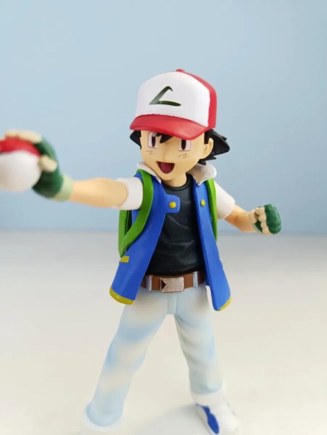 Figura de Ash de Pokémon con gorra roja y blanca, chaqueta azul con detalles verdes, pantalón claro y Poké Ball en la mano, de 14,5 cm de alto, para vitrina, escritorio o regalo a fans del anime, foto 7 de 7